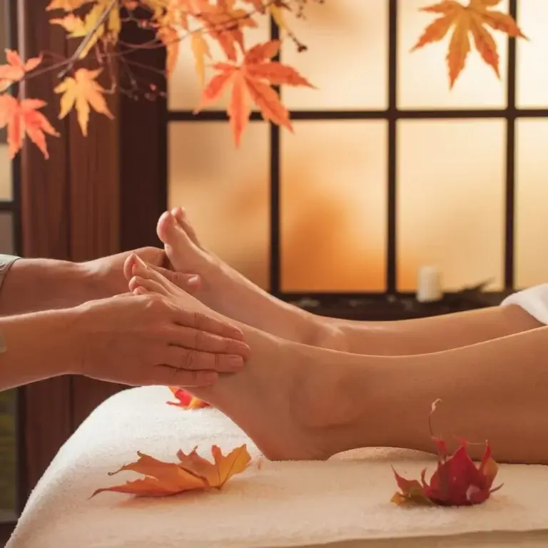 massage des pieds sur le thème de l'automne, feuille orangée et cadre apaisant.