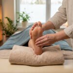 Une personne reçoit une séance de réflexologie plantaire pour soulager la douleur, avec un praticien massant le pied dans une pièce apaisante.